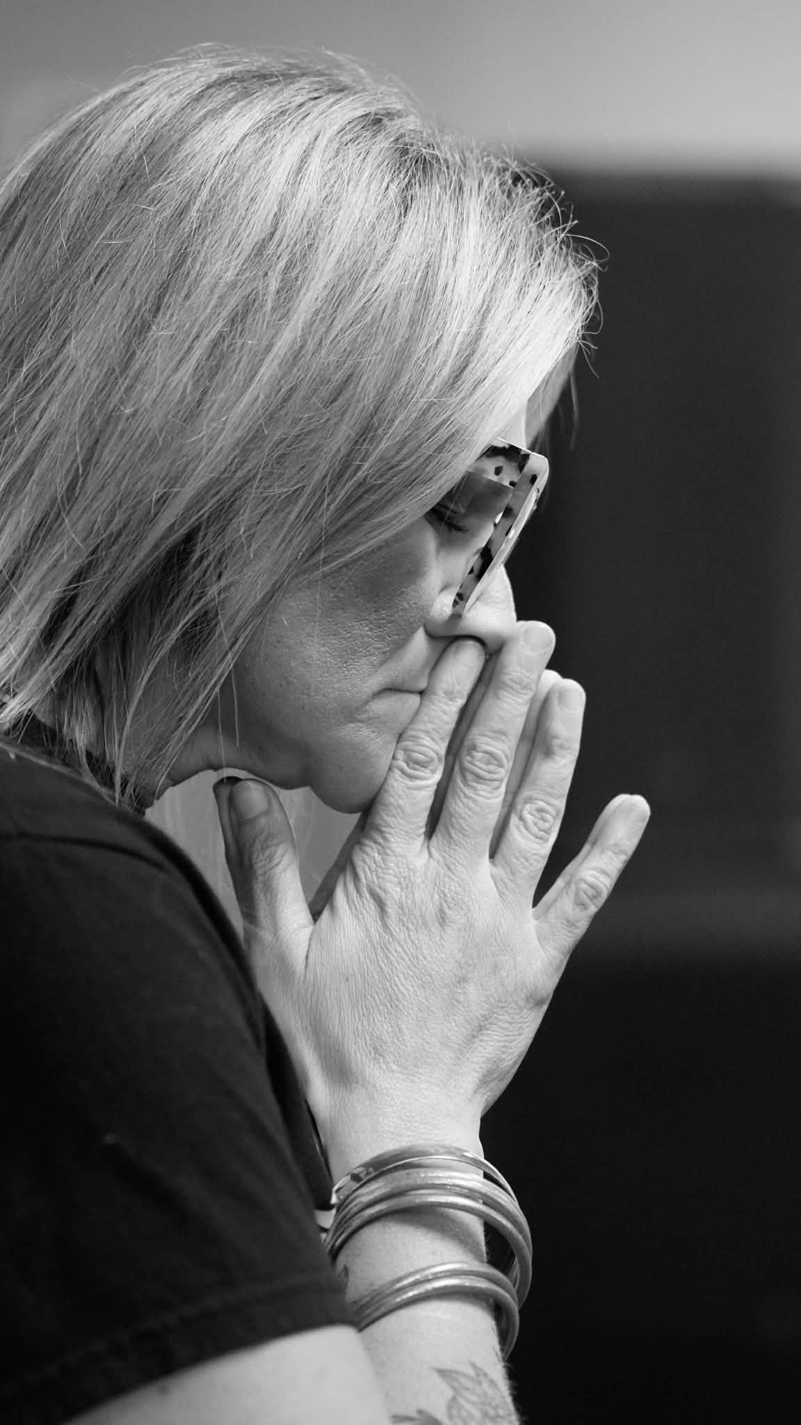 A woman with her hands together in prayer