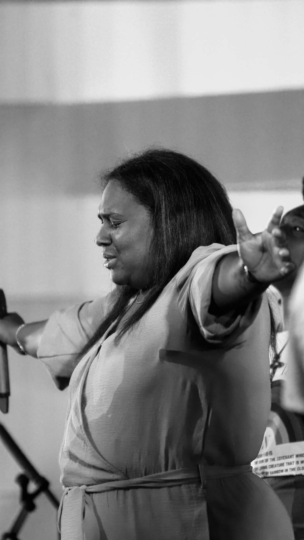 A woman worshipping with her arms open