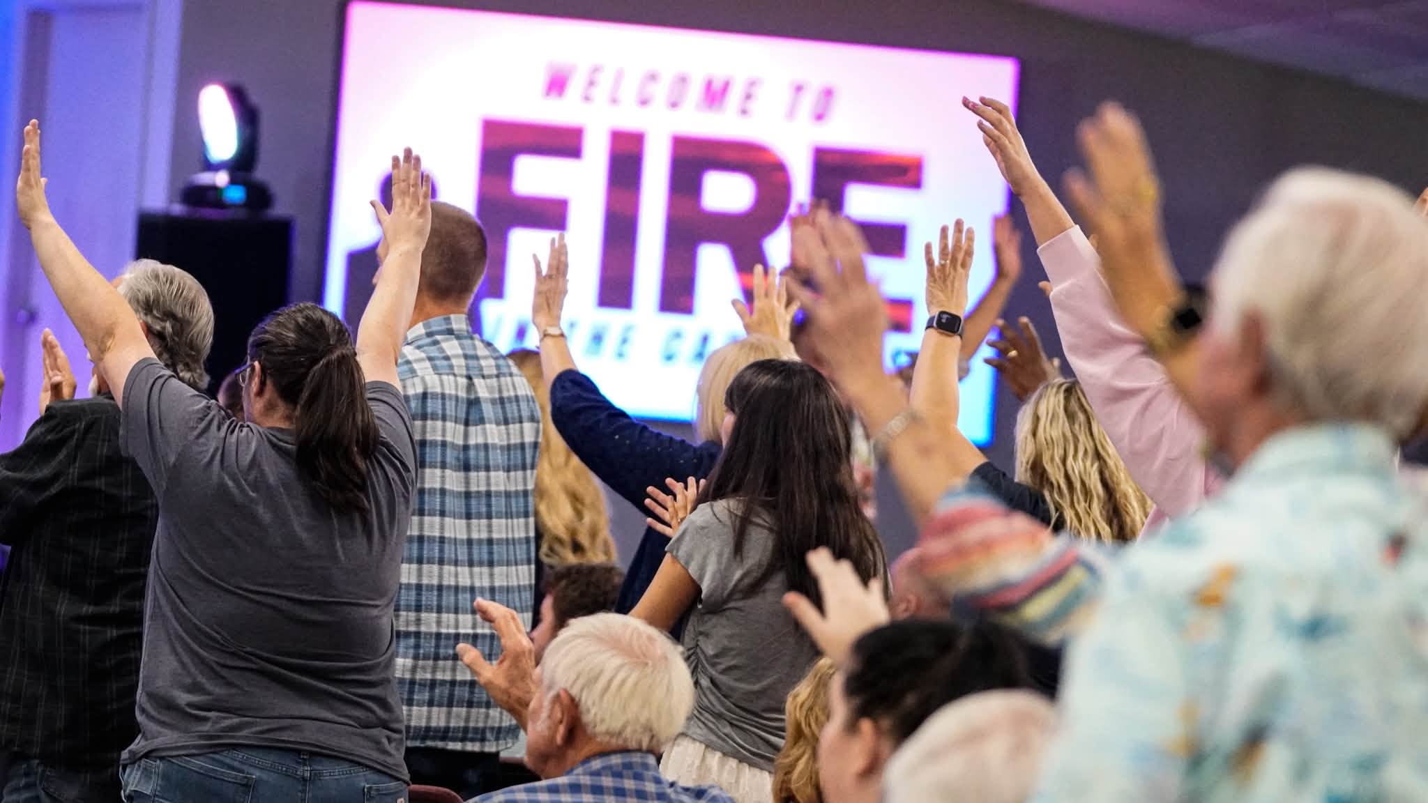 The congregation worshipping together with hands raised